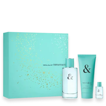 Turquoise Tiffany & Co. gift set with a perfume bottle, lotion tube, and a small fragrance bottle beside a turquoise box with gold confetti pattern.